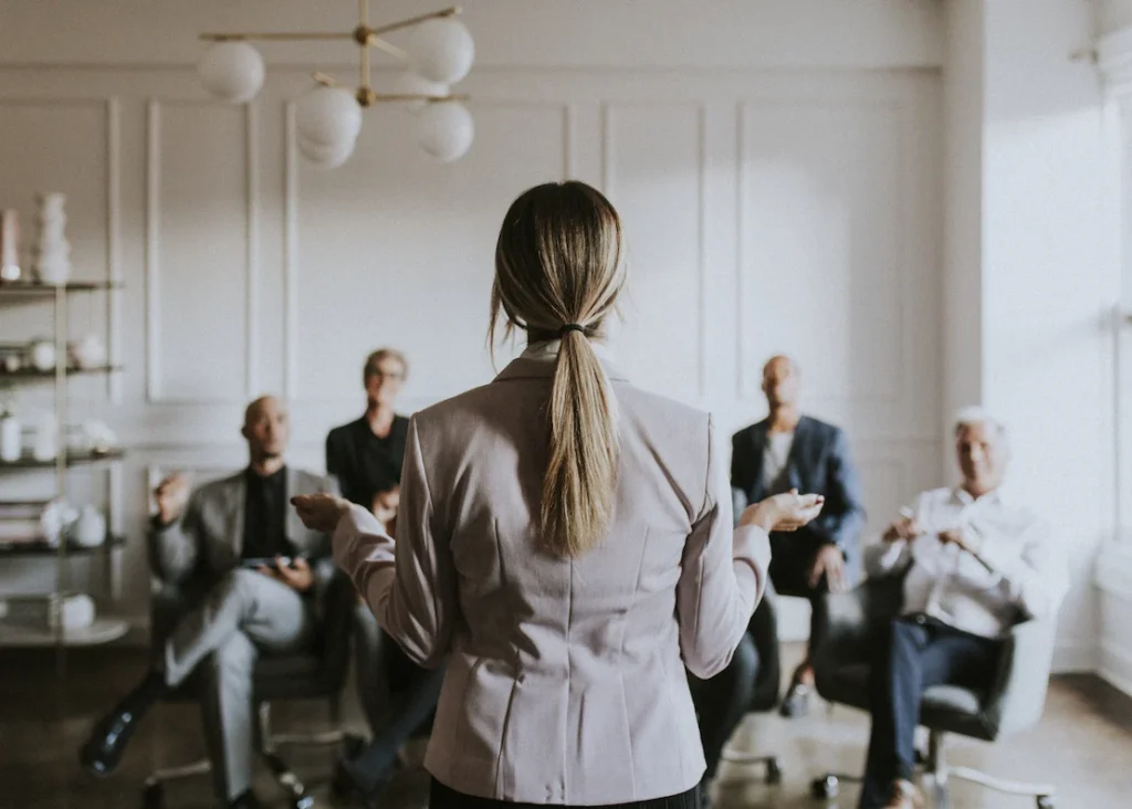 Coach empresarial guía a líderes durante una sesión de coaching e hipnosis para potenciar el liderazgo y la claridad mental en equipos de trabajo