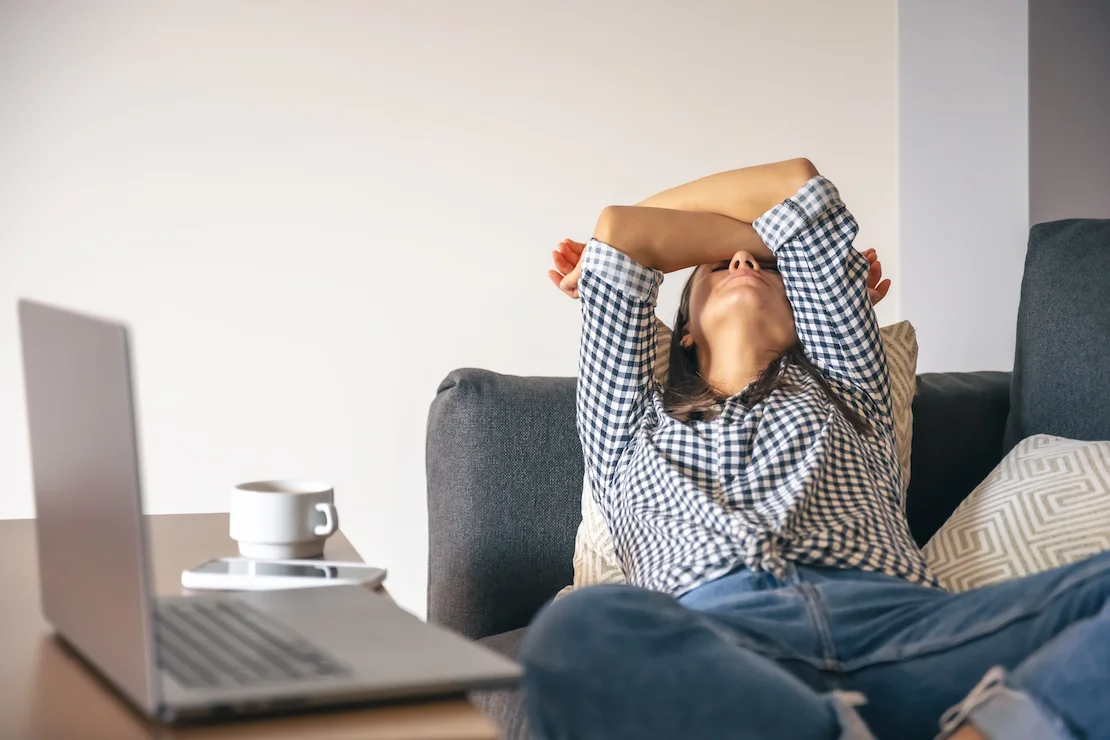 Mujer agotada frente al ordenador por burnout laboral, ejemplo de estrés en el trabajo que puede tratarse con hipnoterapia